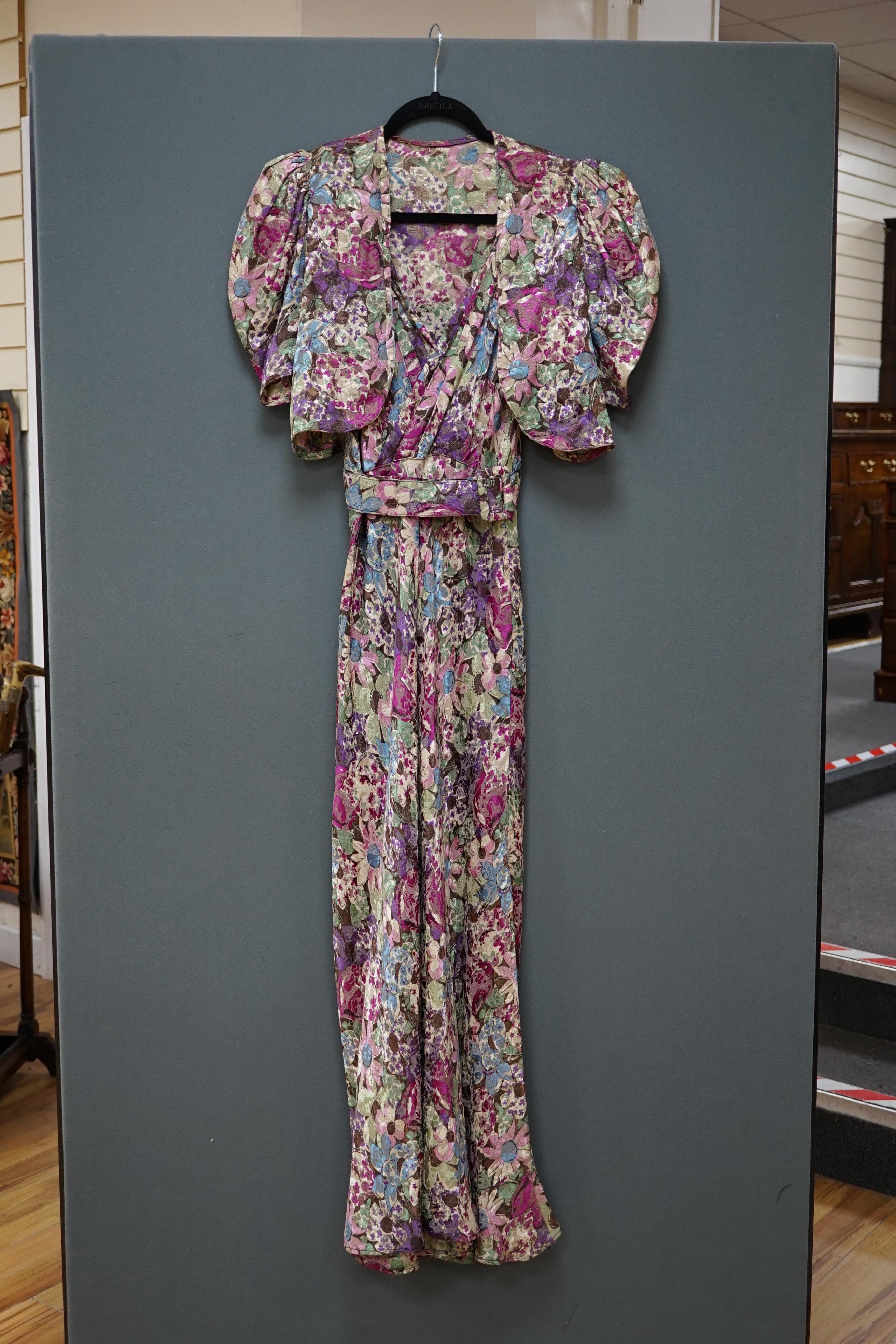 An early 1940’s floral lurex evening dress and bolero, handmade brightly coloured floral lurex, bias cut, with a cross over plunging bodice, half belt and matching bolero, 40cm front bodice arm to arm. Condition - the co